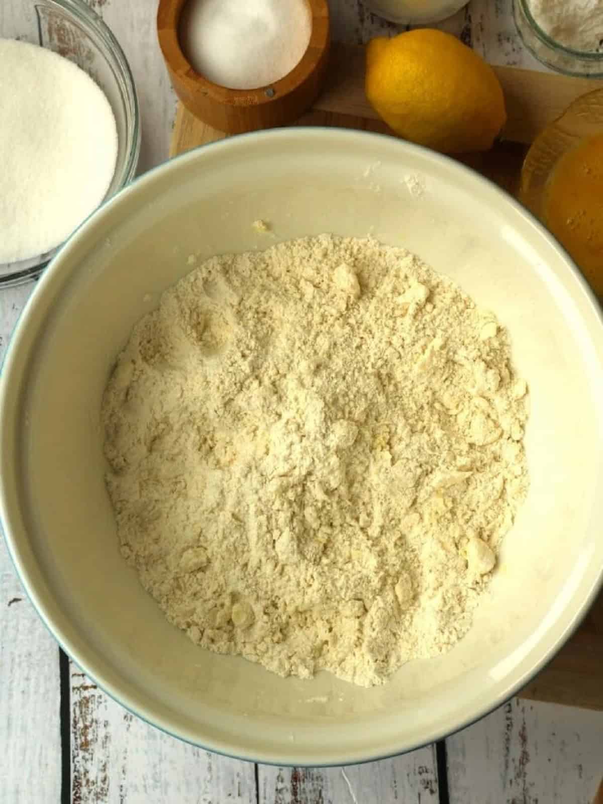 Flour and butter crumbled together in mixing bowl.