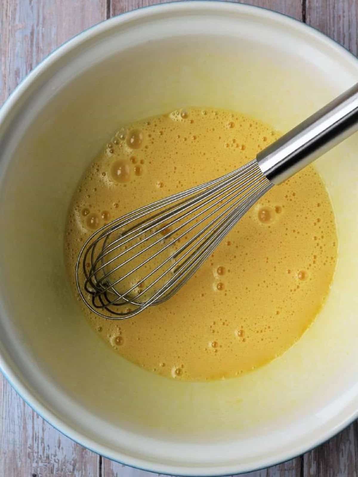 Eggs, sugar and oil whisked in large bowl for anise biscotti recipe.