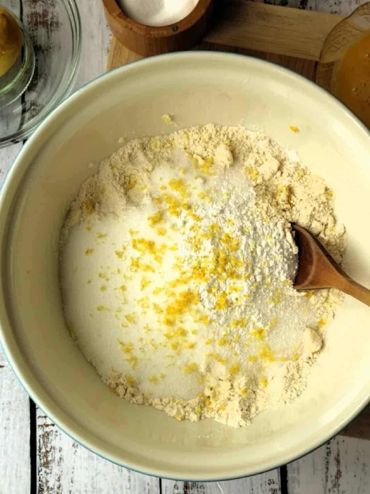 Lemon zest added to bowl with flour, sugar and butter.