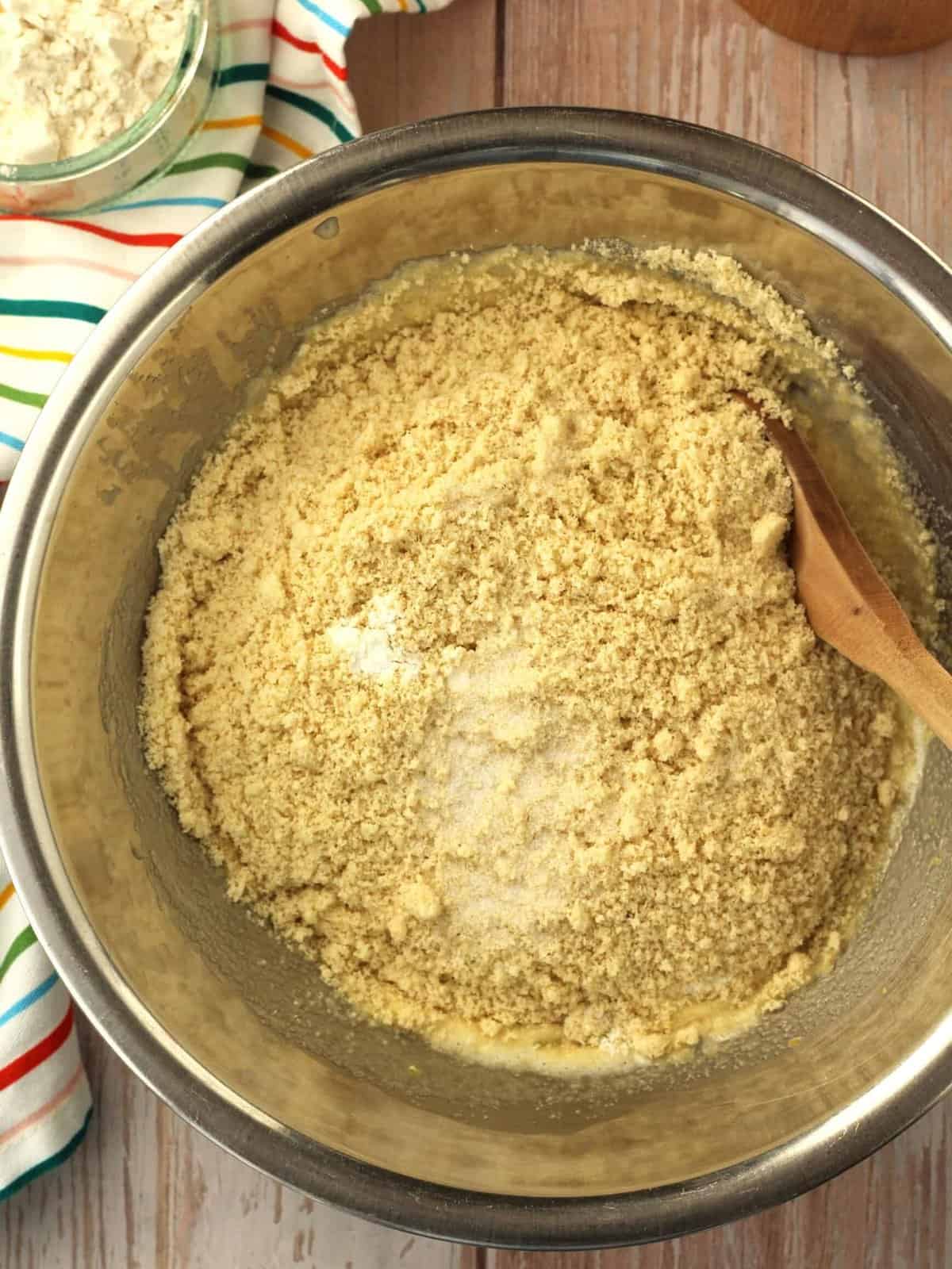 Almond flour added to bowl with batter for lemon almond cookies.