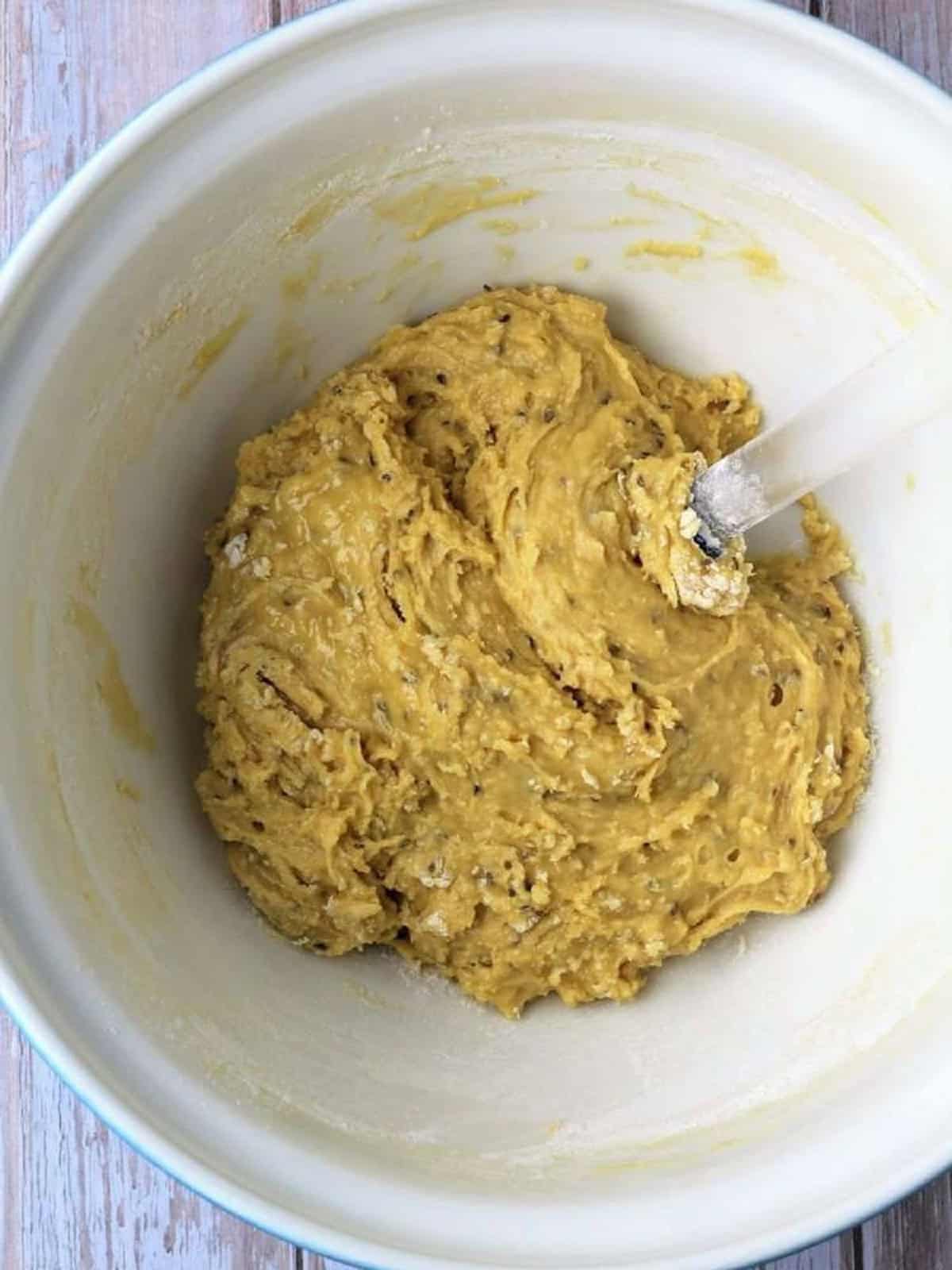 Sticky dough for biscotti with anise seed in large bowl.