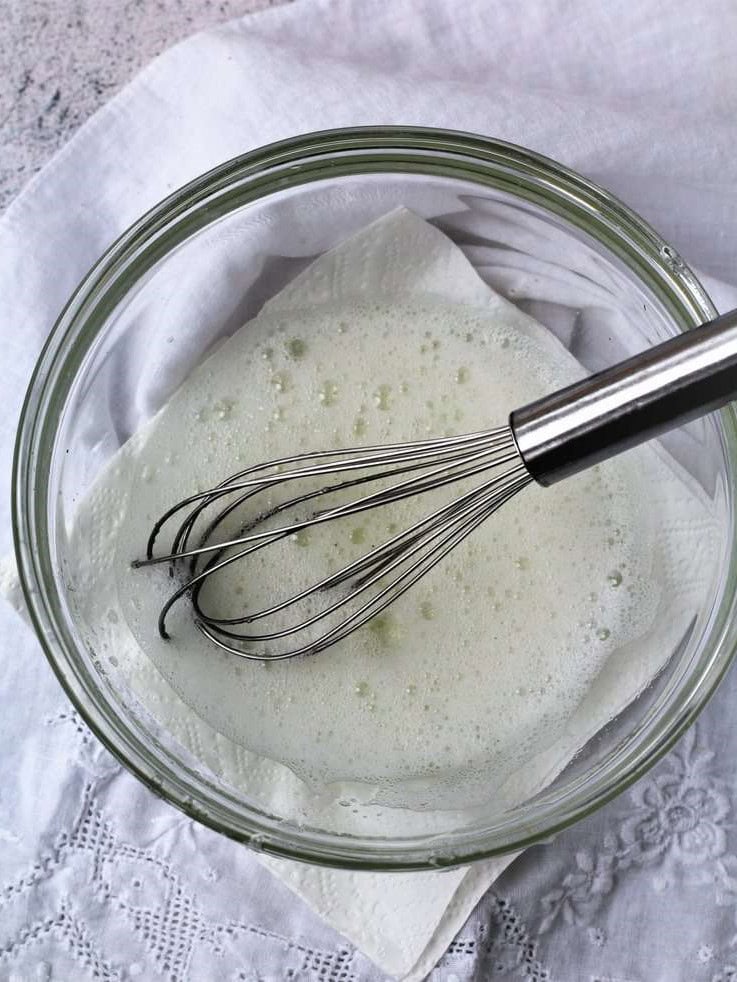 Whisked egg whites in glass bowl.