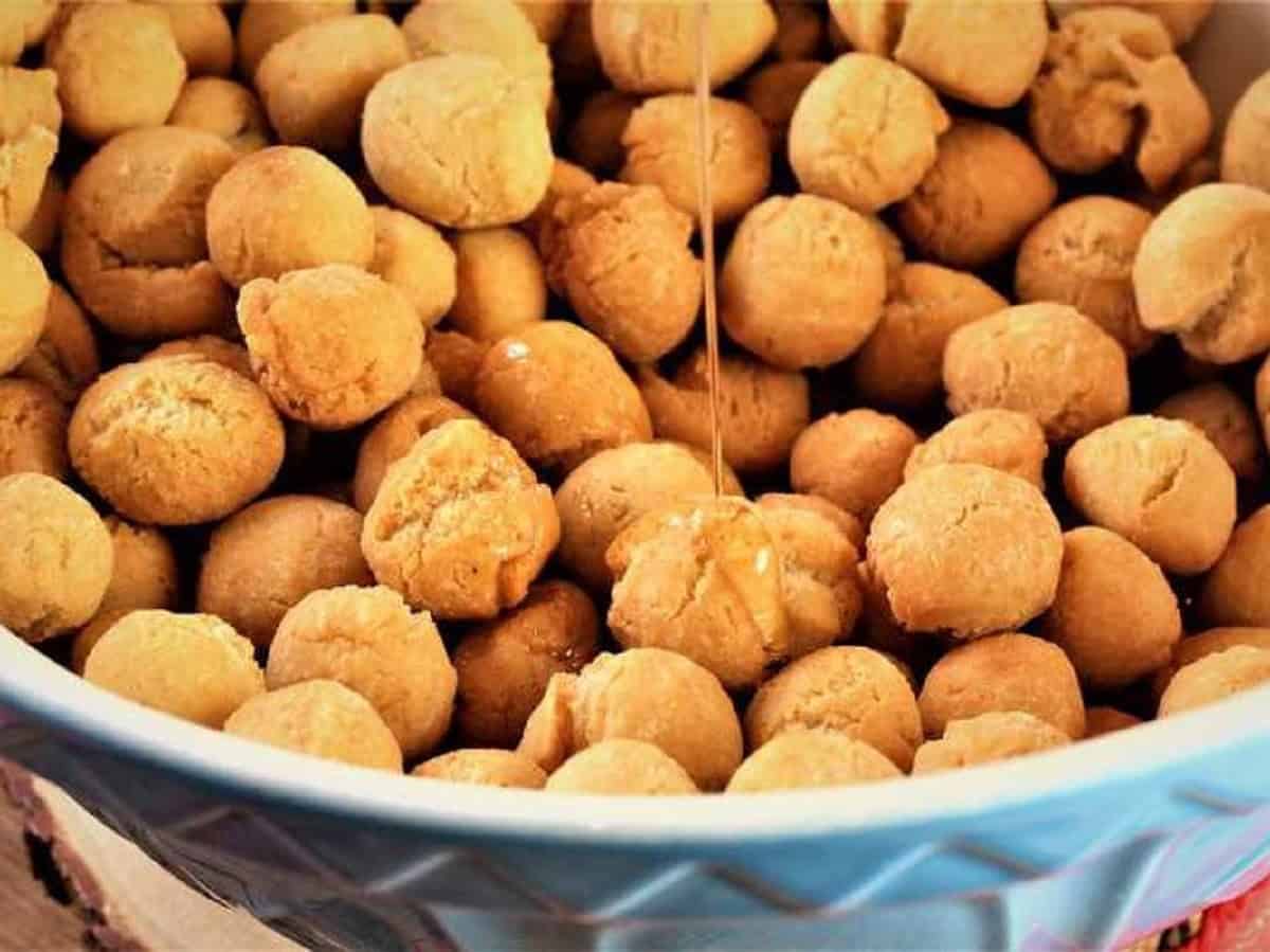 Pignolata in large bowl tossed with honey.