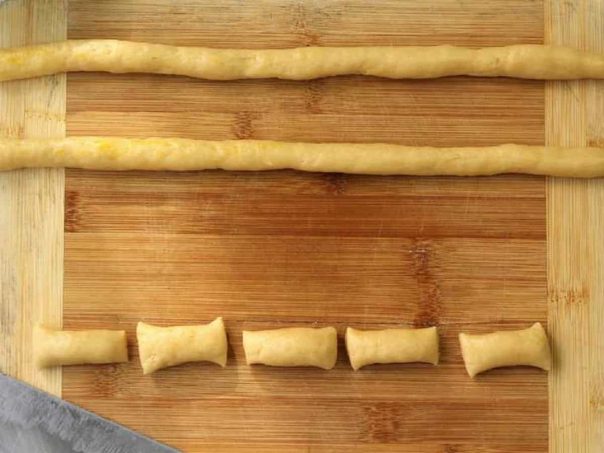 Sesame seed cookie dough rolled into ropes and cut into pieces.