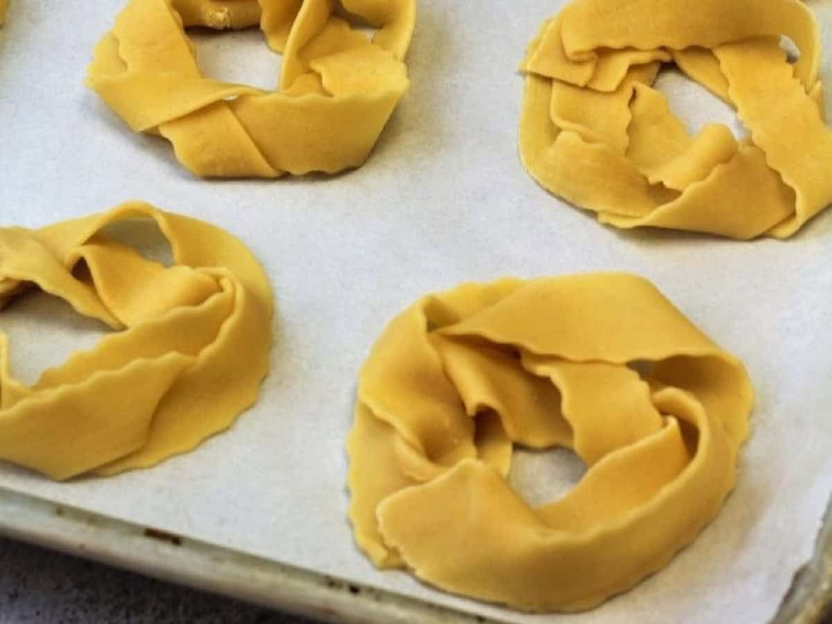 Braided pignolata dough shaped into rings.