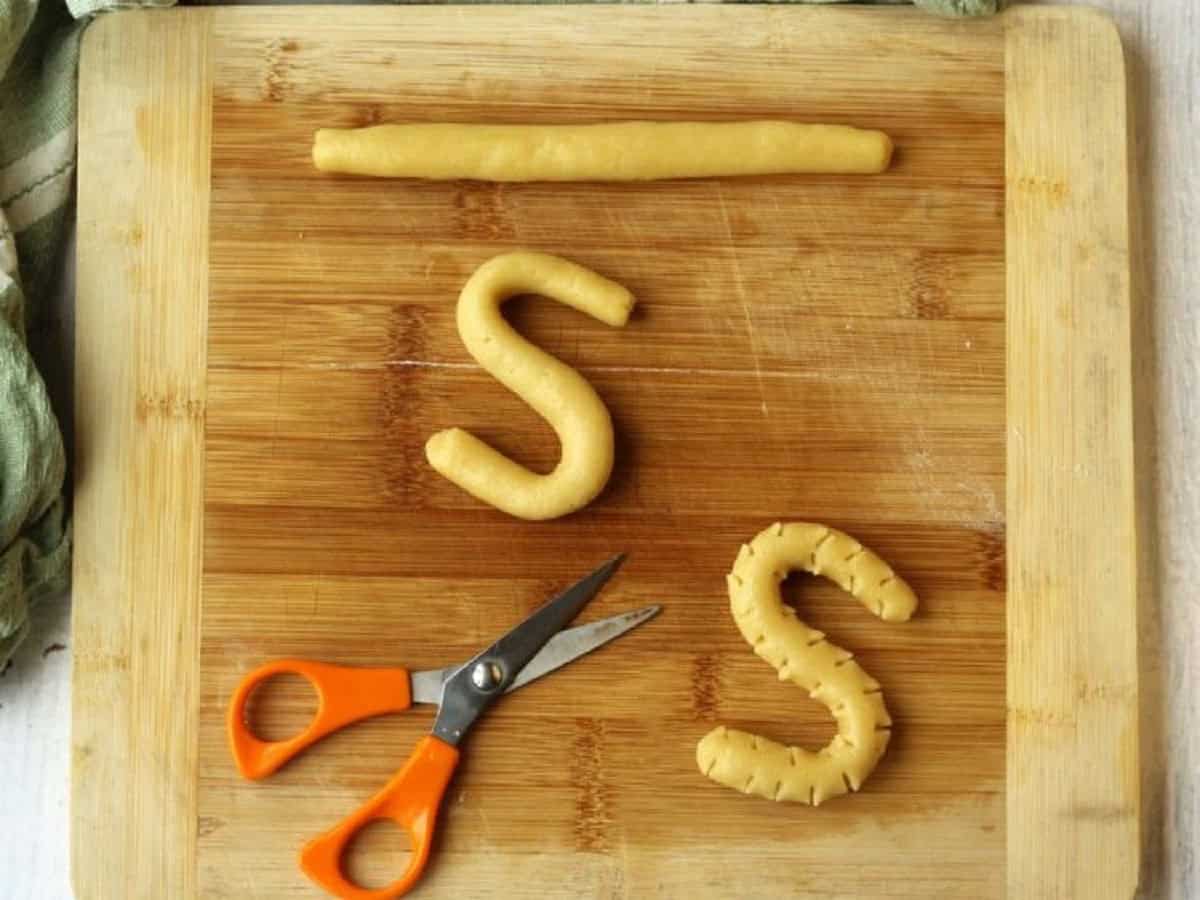 Cookie dough rolled into ropes to shape into S cookies.