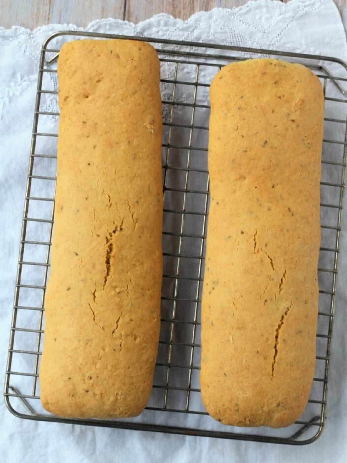 Baked anise seed biscotti loaves on wire rack.