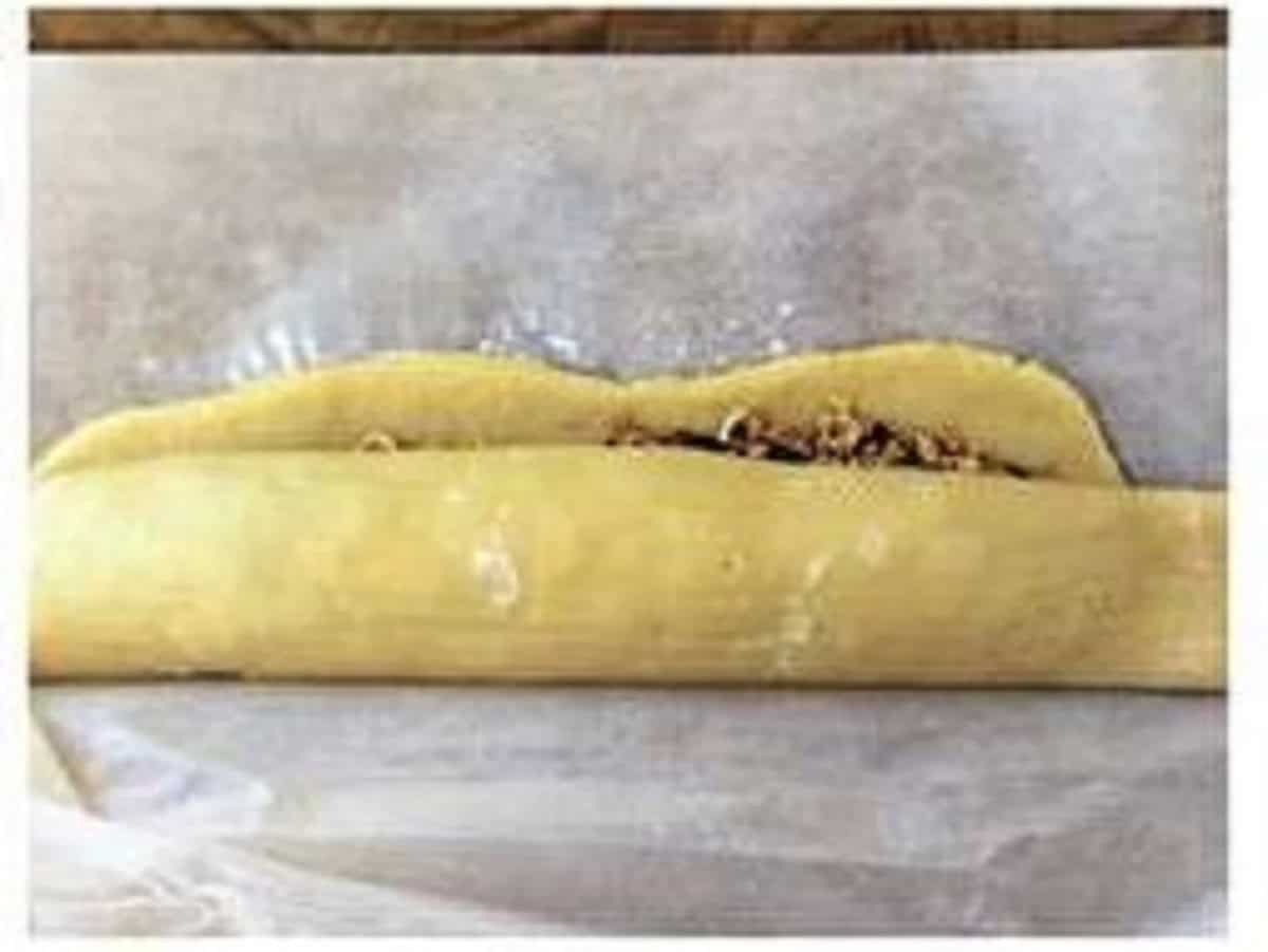 Shortcrust cookie dough filled with nuts and jam rolled into log.