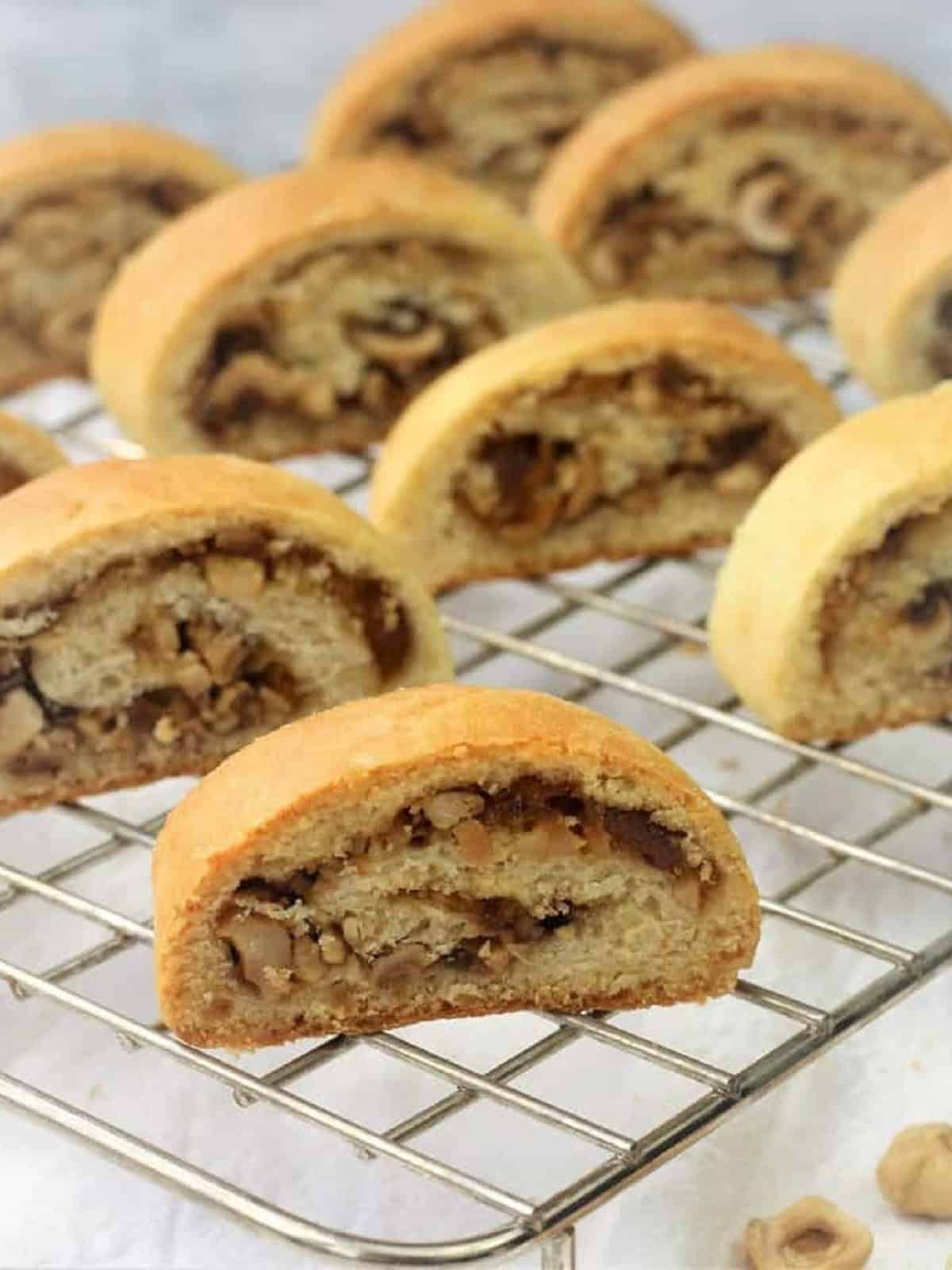Italian nut and jam rolled cookies on wire rack.