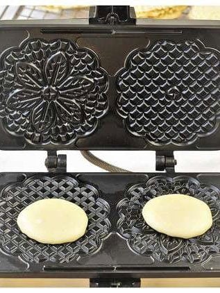 Pizzelle cookie batter on pizzelle maker.