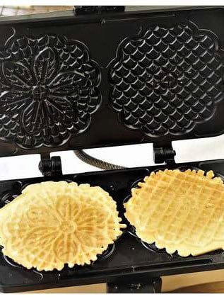 Pizzelle cookies cooked on a pizzelle iron.