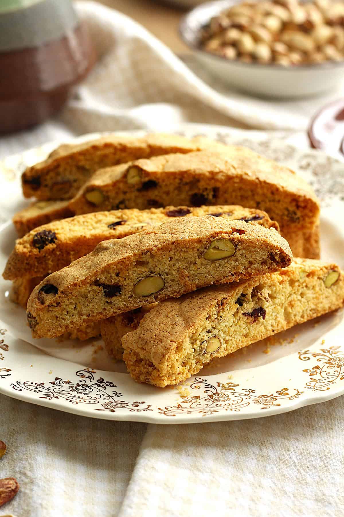 Cornmeal biscotti with cranberries and pistachios piled on plate.