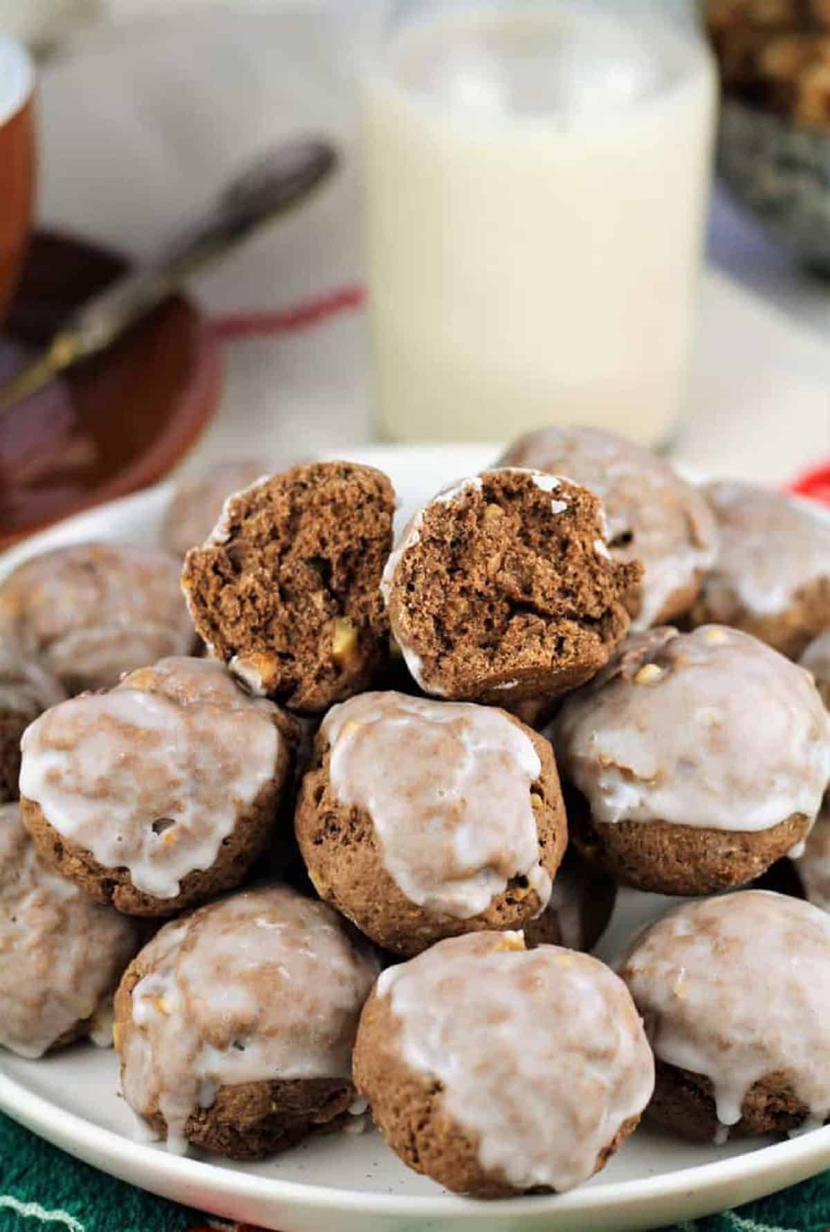 Tetù (Sicilian Chocolate Spice Cookies) Tetù cookies piled on plate with top one cut open next to glass of milk.