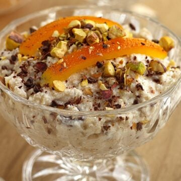 Cuccia (wheat berry and ricotta pudding) in glass topped with candied orange peel and pistachios.