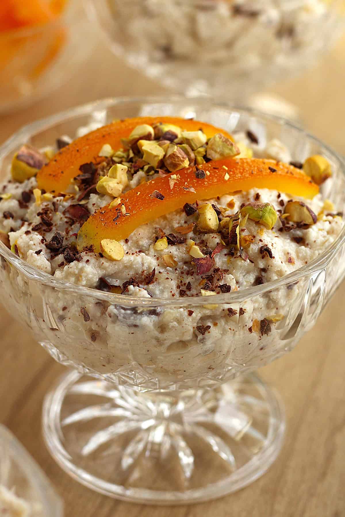 Cuccia (wheat berry and ricotta pudding) in glass topped with candied orange peel and pistachios.