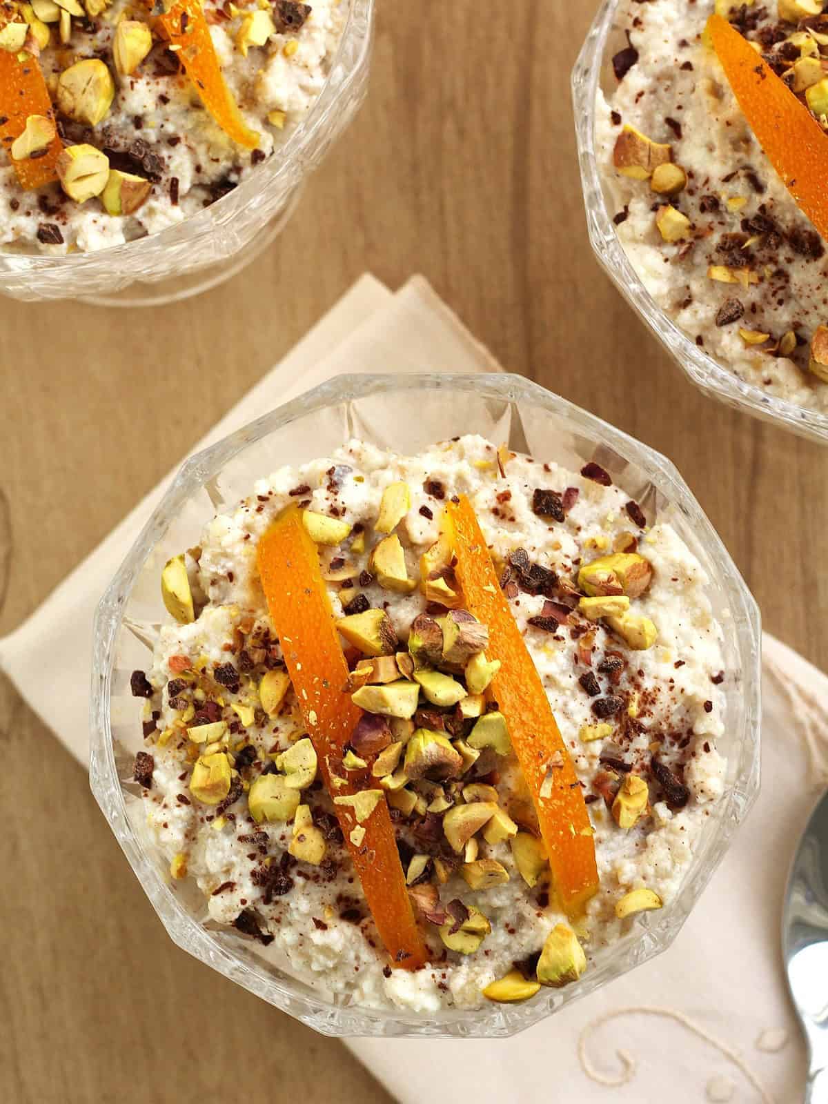 Glasses filled with Sicilian ricotta and wheat berry pudding topped with candied orange and chopped pistachios.