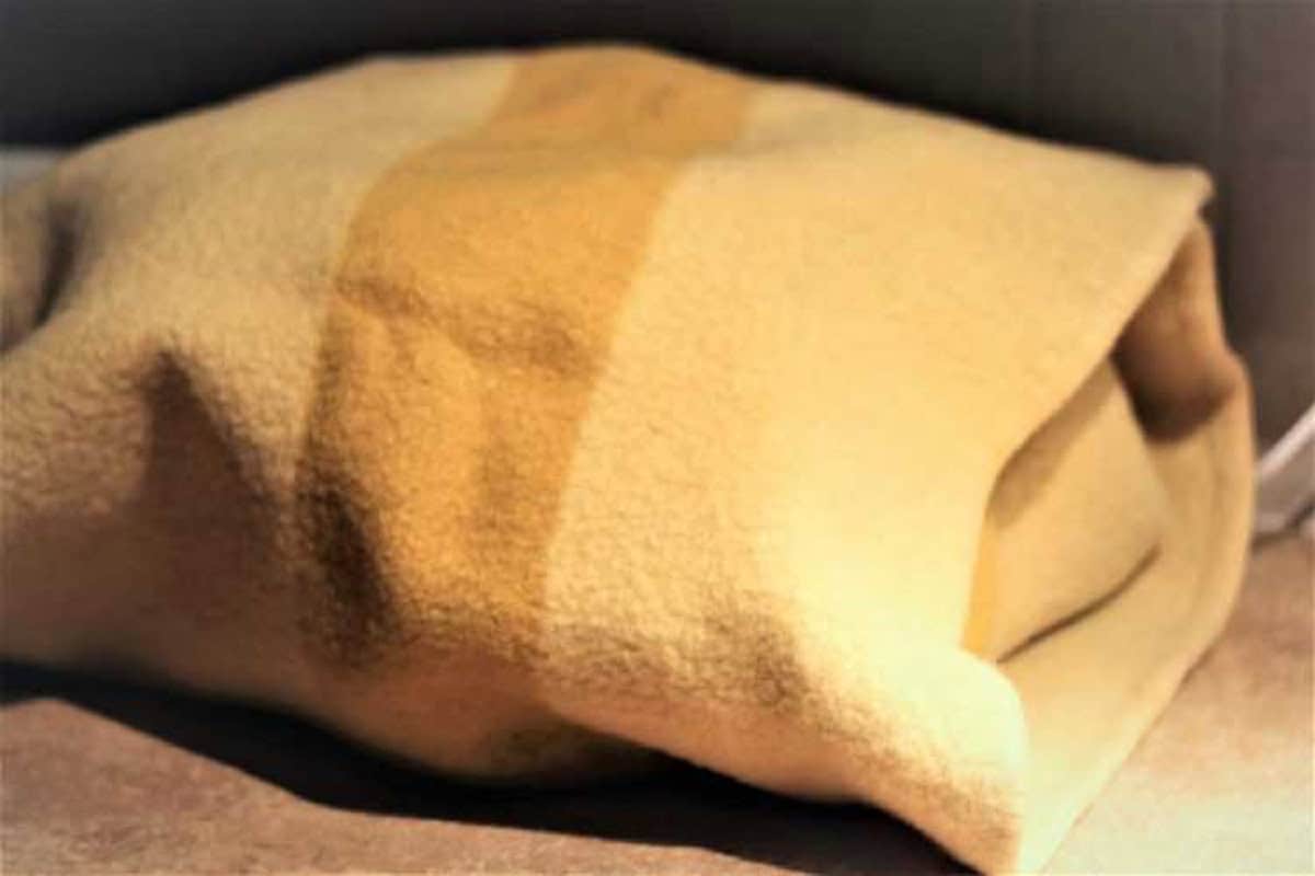 Heavy wool blankets covering pot with sfinci dough.