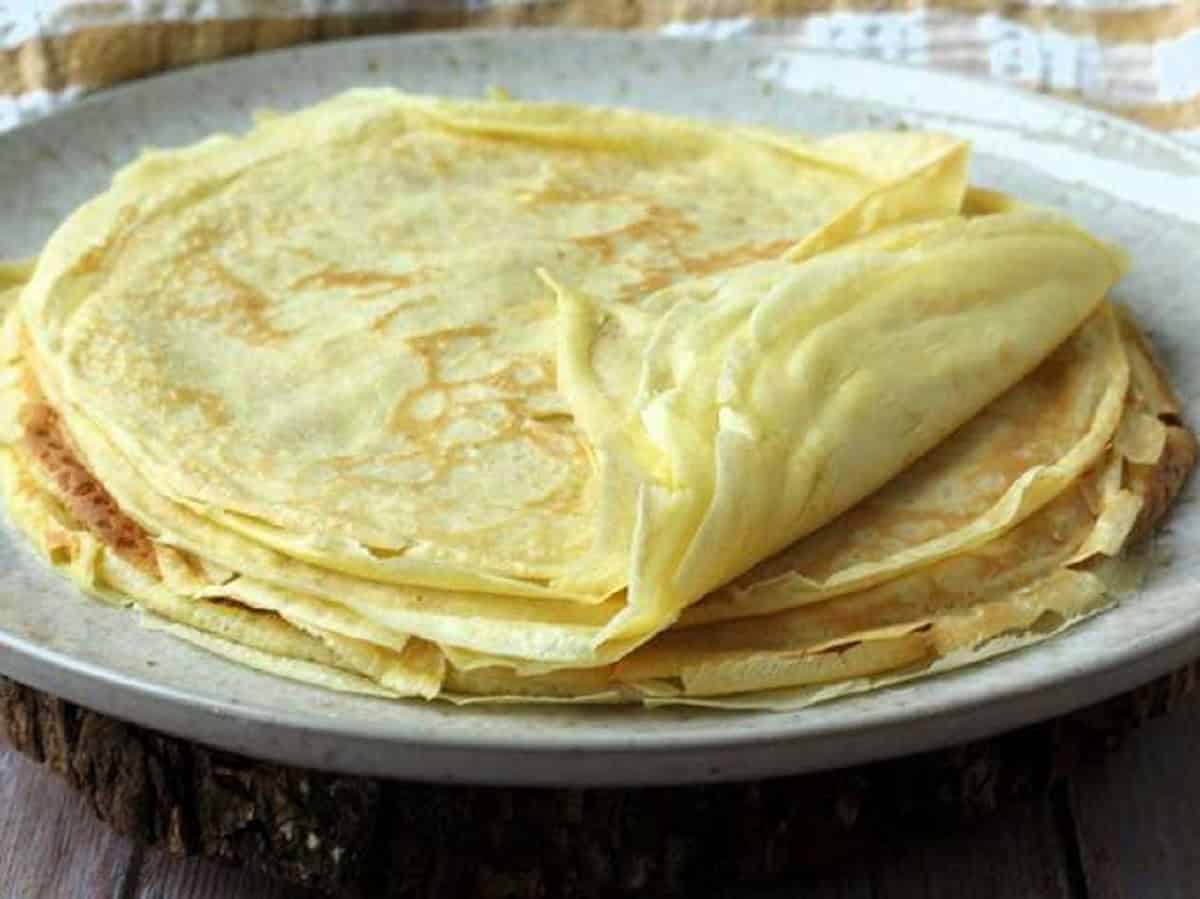 Stack of thin crepes on a plate.