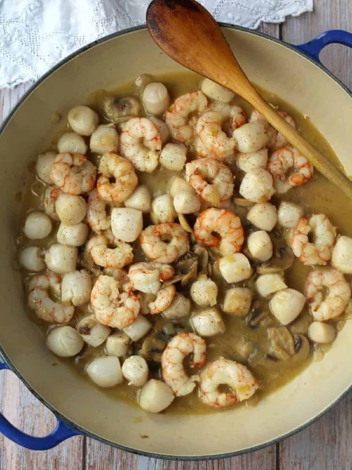 Shrimps and scallops sautéed in skillet for crepe filling.