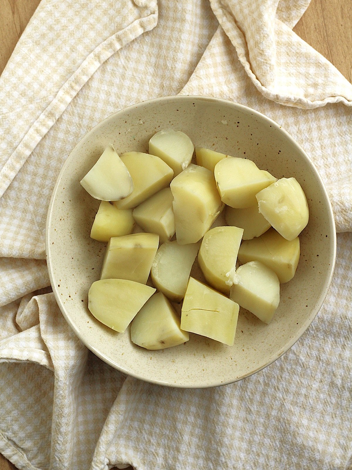 Boiled cubed potatoes in bowl for cod croquettes.
