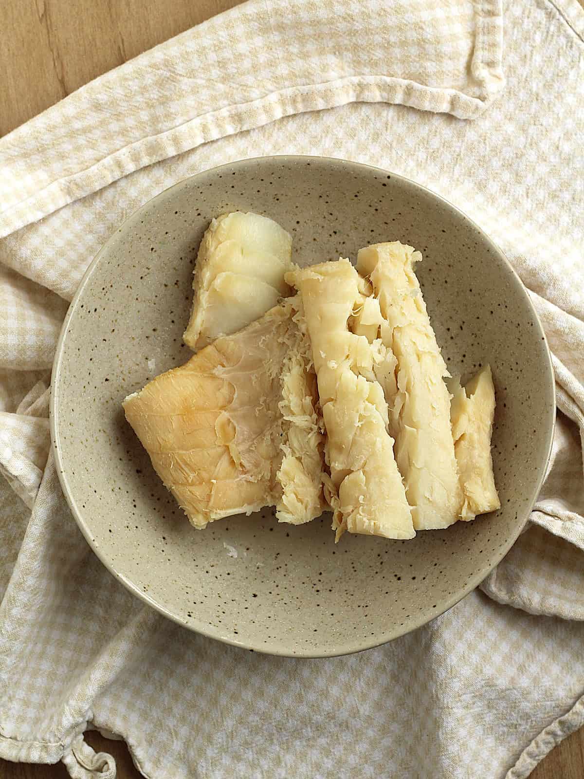 Boiled salt cod in bowl for cod croquettes.