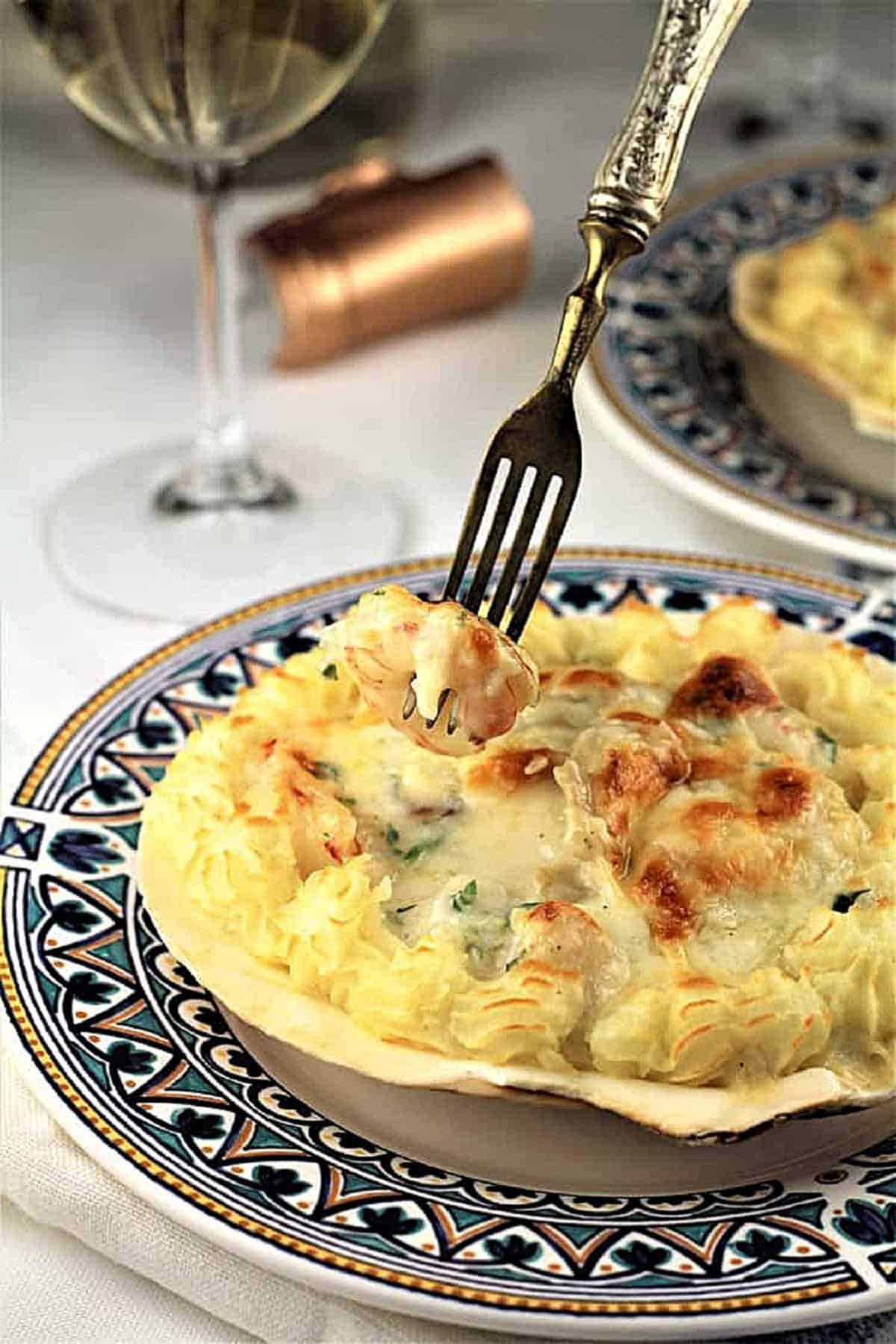 Coquilles St-Jacques with fork picking up a piece of shrimp.