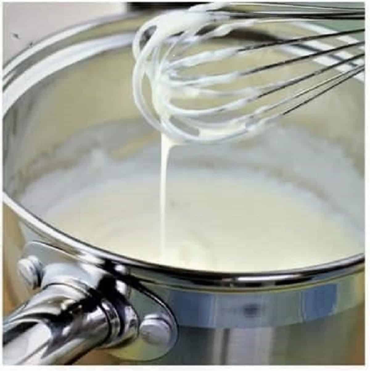 Bechamel sauce whisked in sauce pan.