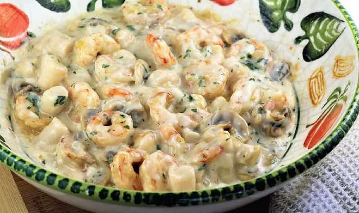 Seafood stirred into bechamel sauce for coquilles St-Jacques.