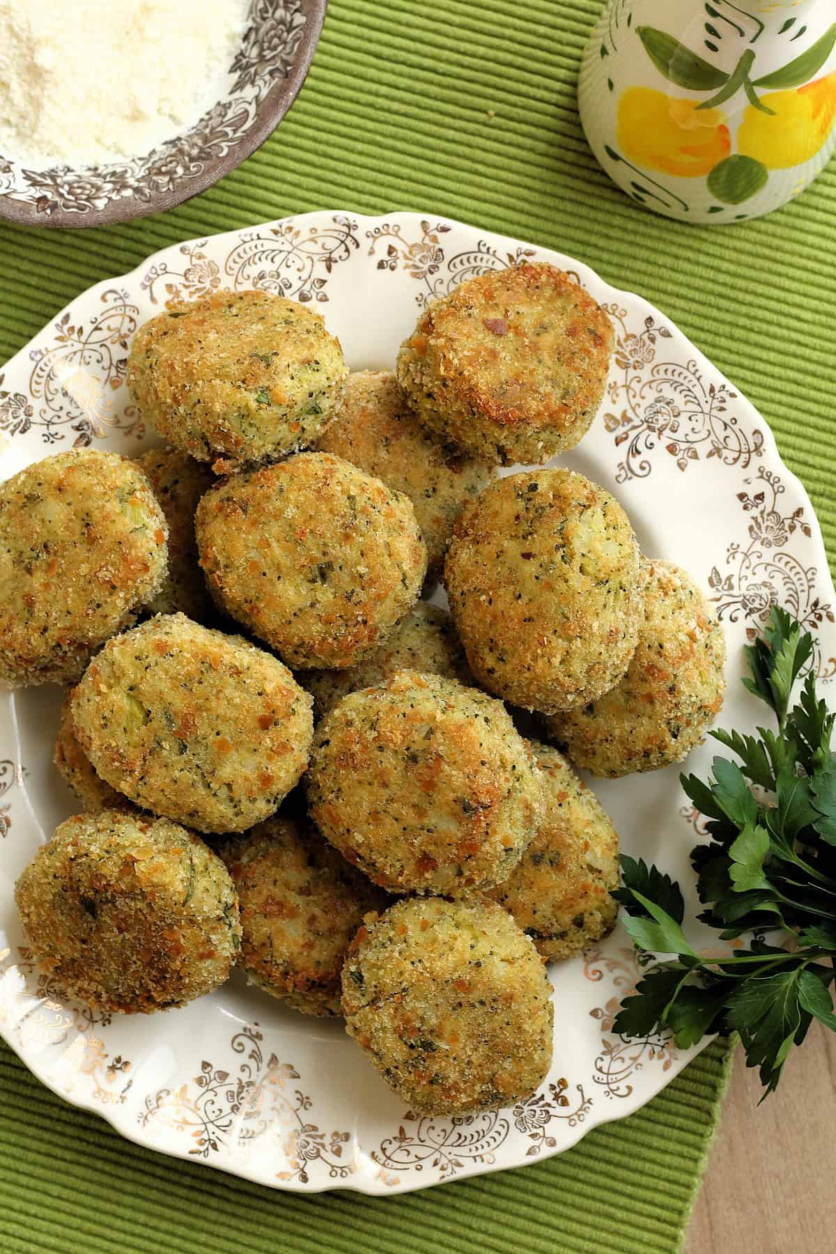 Cheesy baked potato broccoli meatballs on serving plate with sprig of parsley.
