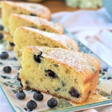 Blueberry olive oil cake wedges on serving plate.