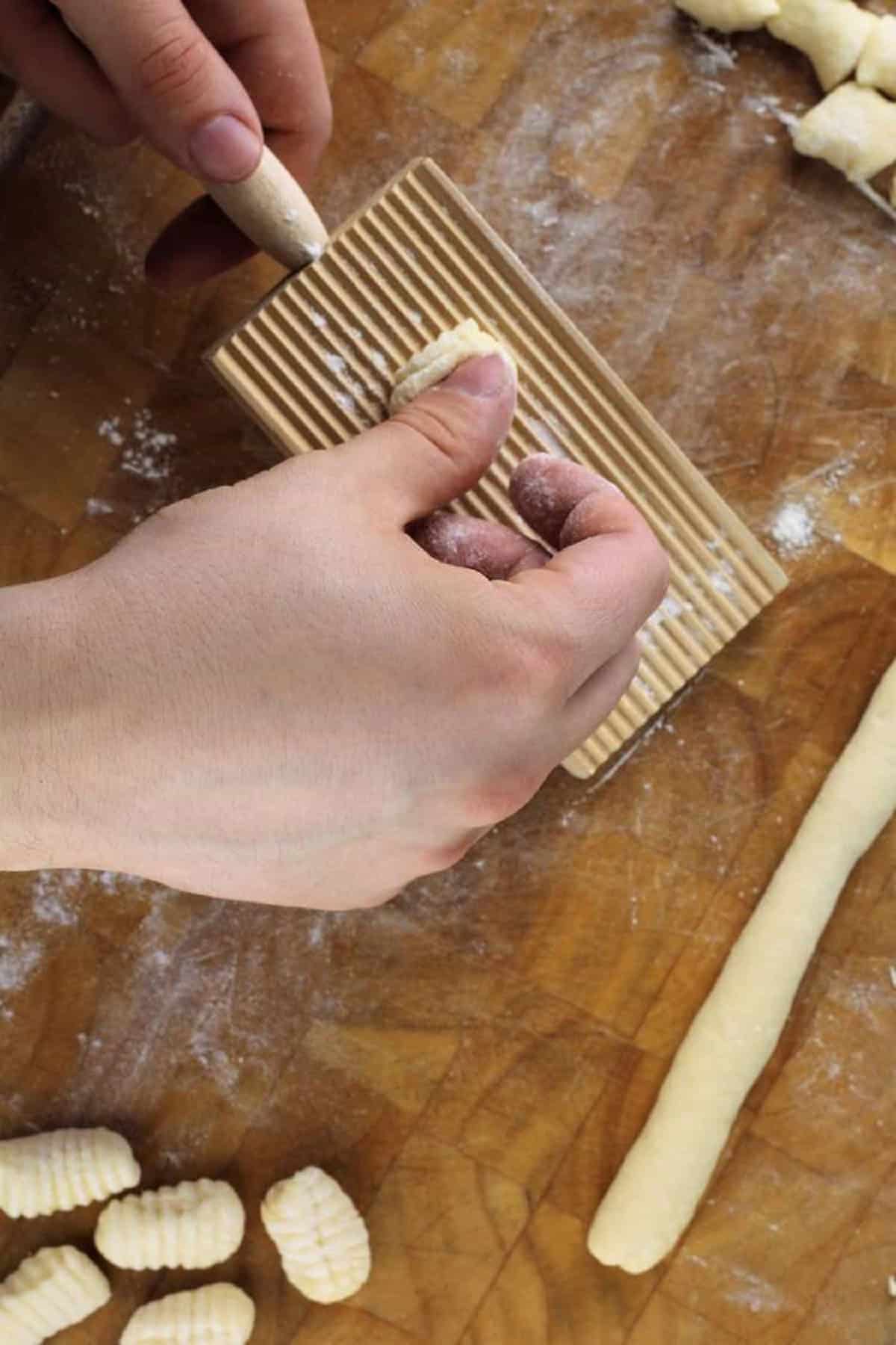 How to roll gnocchi on a wood gnocchi board.