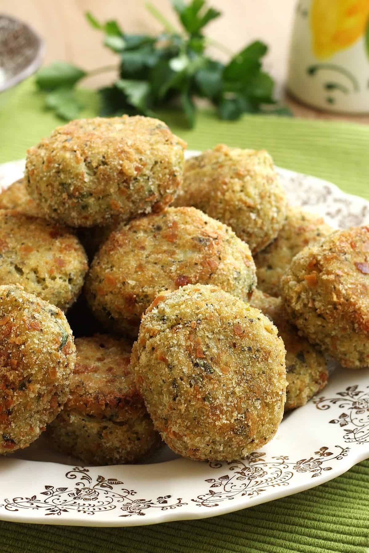 Baked breaded broccoli potato cakes on plate.