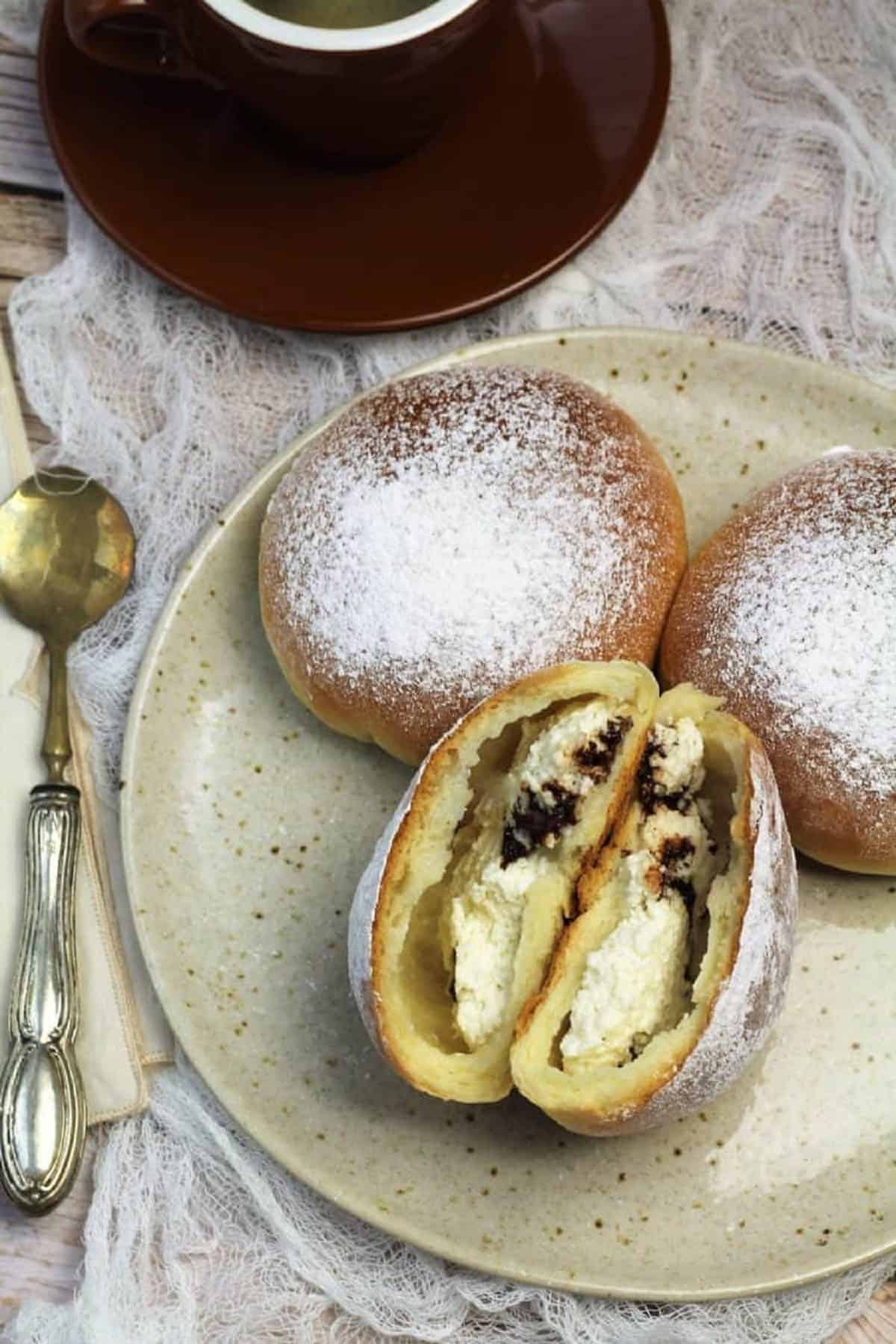 Sicilian iris filled with ricotta and chocolate chips cut open on plate.