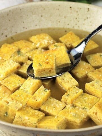 Bowl of zuppa imperial, with frittata squares, spooned.