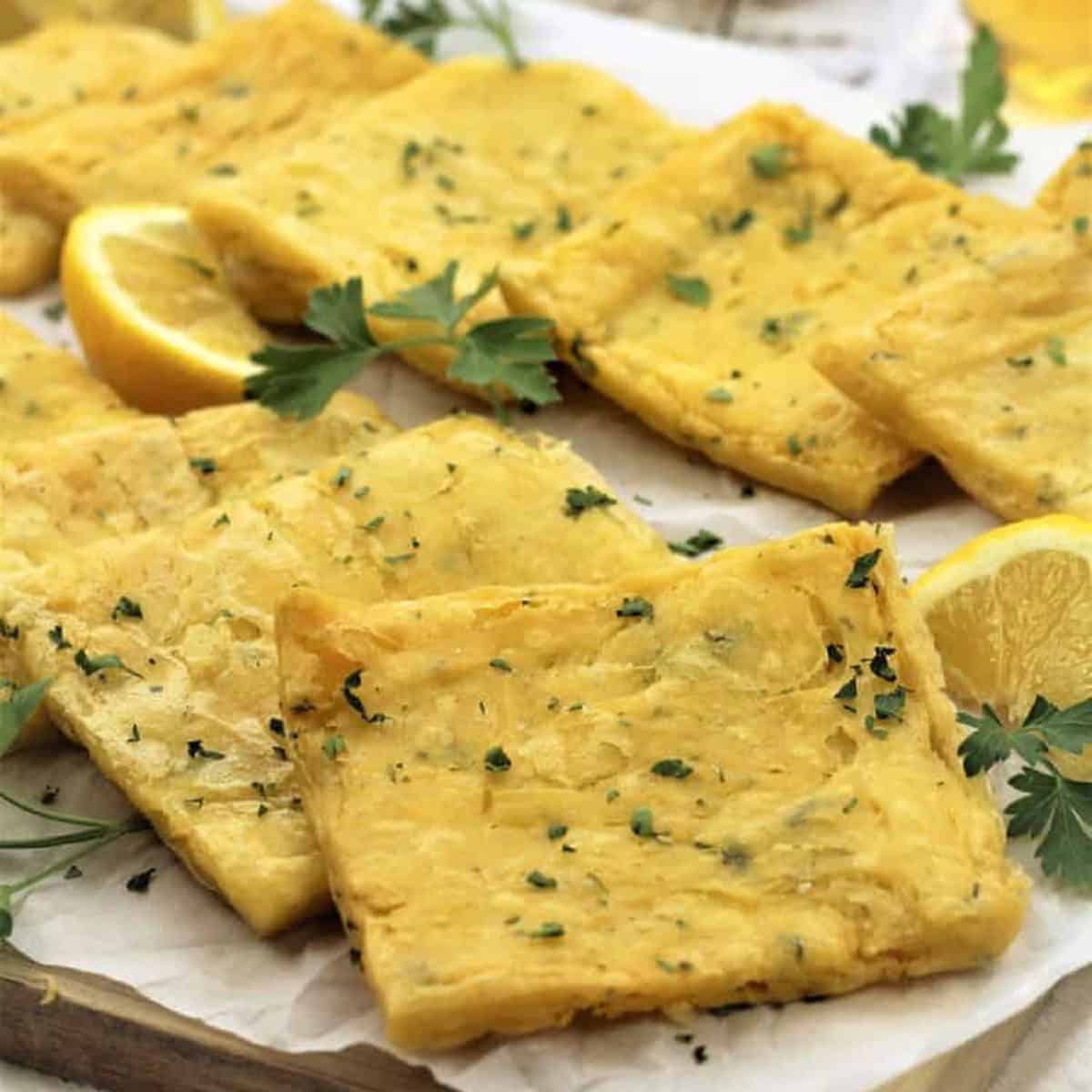 Fried panelle squares with lemon wedges and parsley.