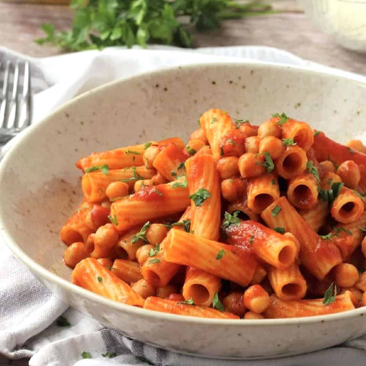 Bowl of chickpea pasta with tomato sauce.