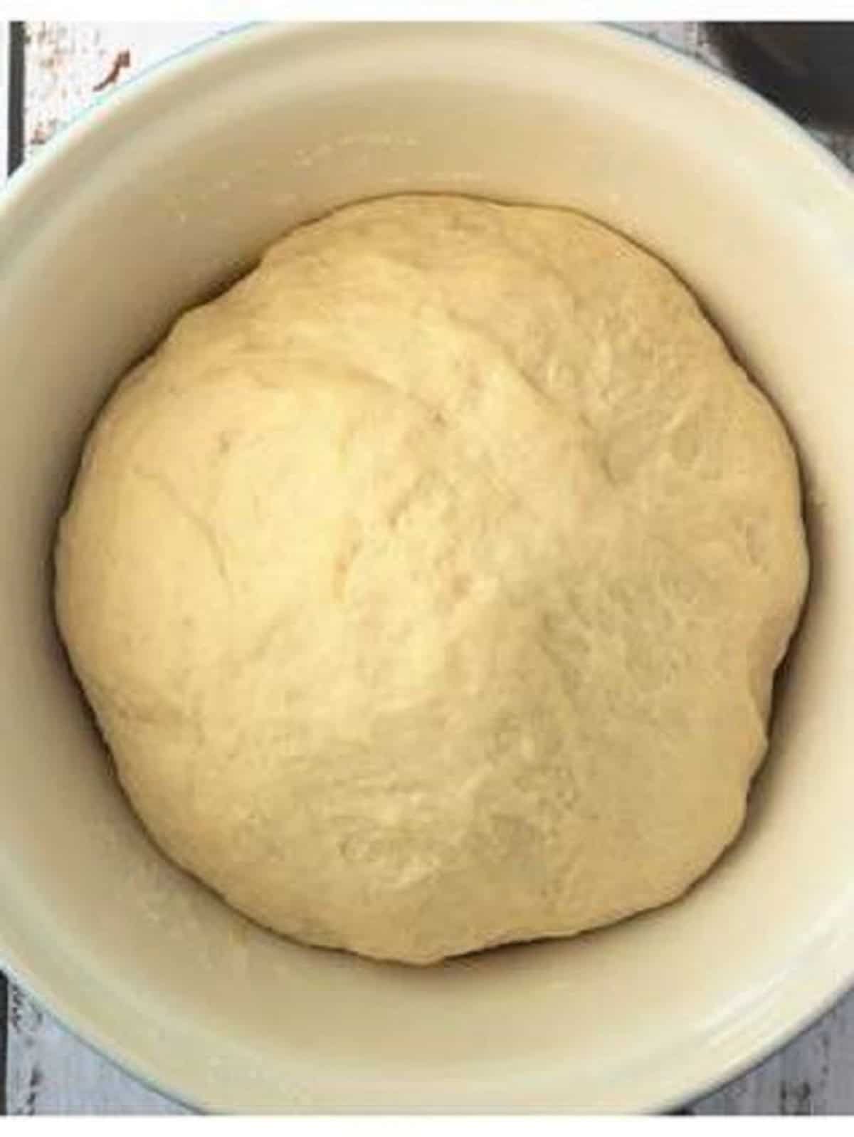 Proofed sfincione dough doubled in bulk in large bowl.
