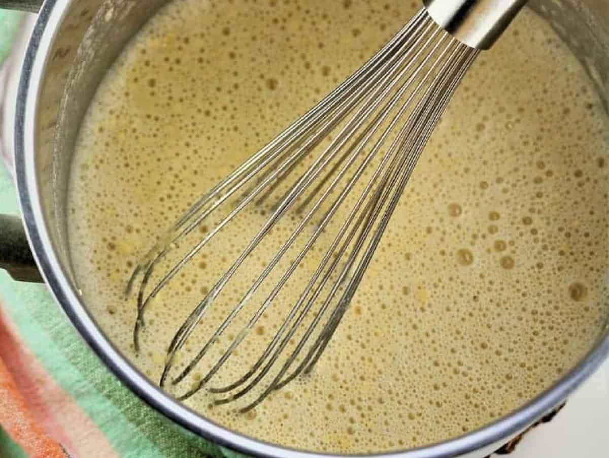 Whisked chickpea flour, salt and water in sauce pan for panelle.