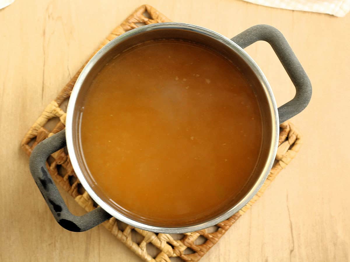 Simmering vegetable broth in sauce pan for zucchini risotto.