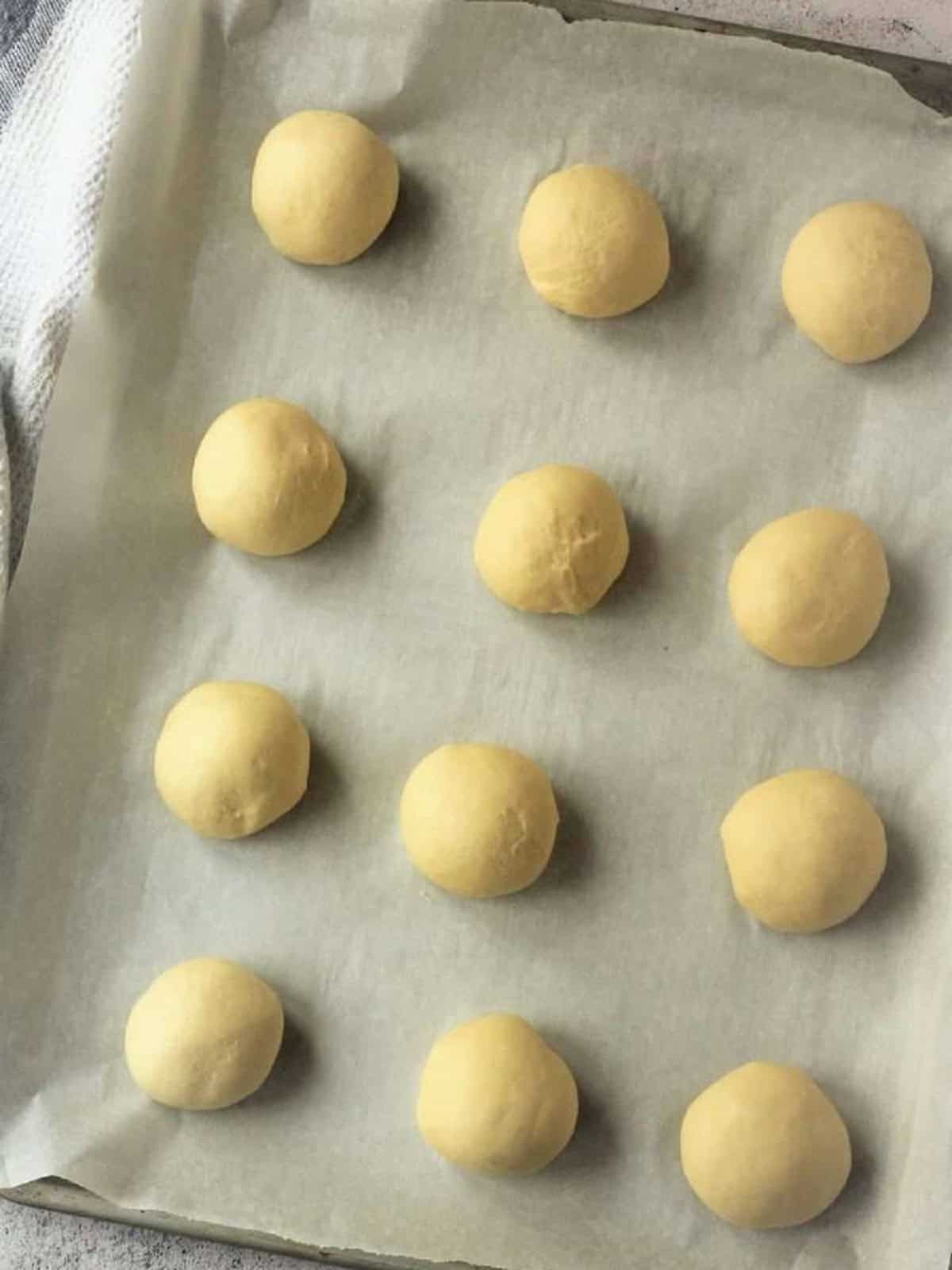 Balls of Sicilian iris dough on baking sheet.