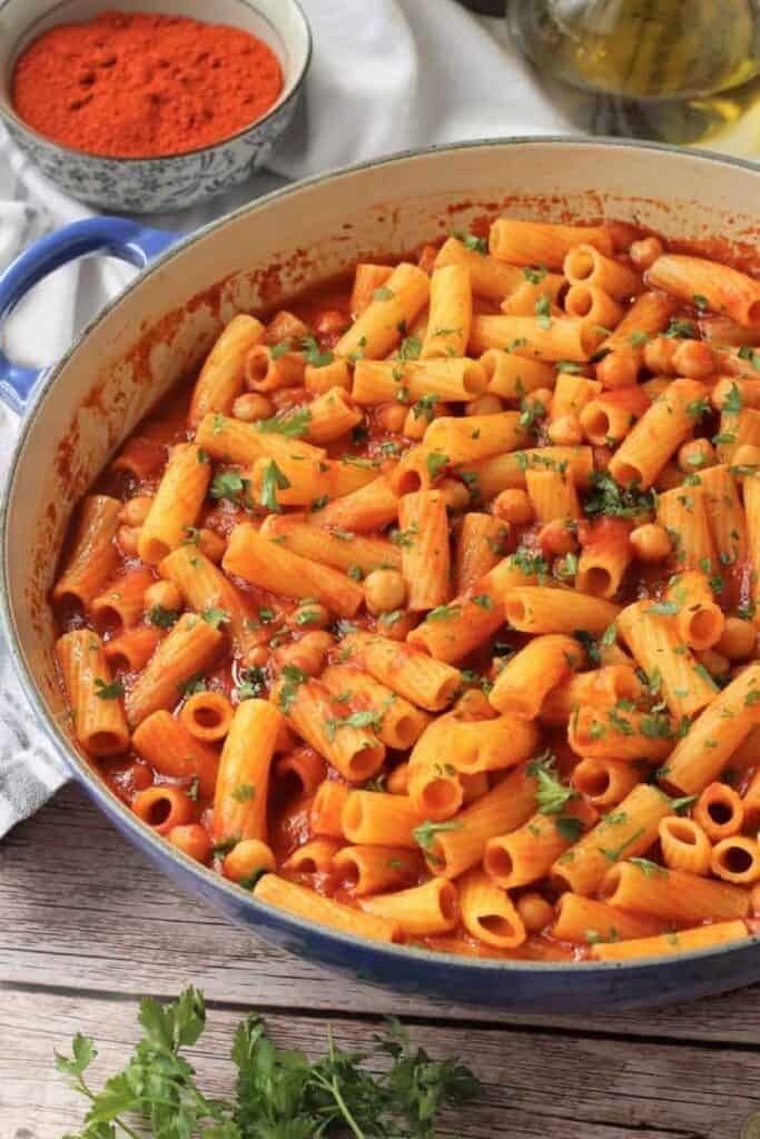 Pasta with chickpeas in tomato sauce in large skillet.