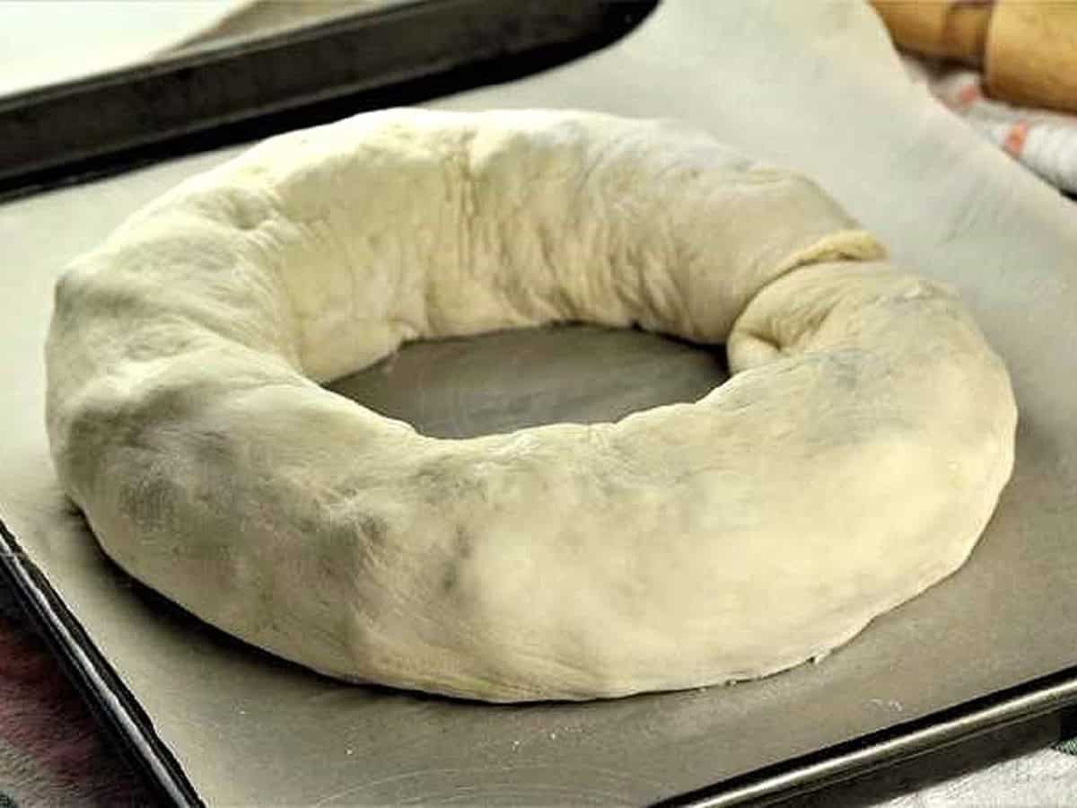 Bignolati shaped into a sphere on baking sheet.