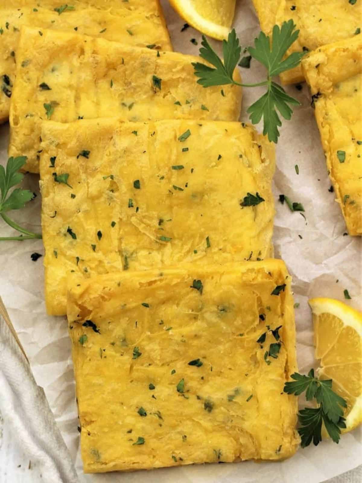 Panelle (Sicilian chickpea fritters) squares with lemon wedges and parsley.