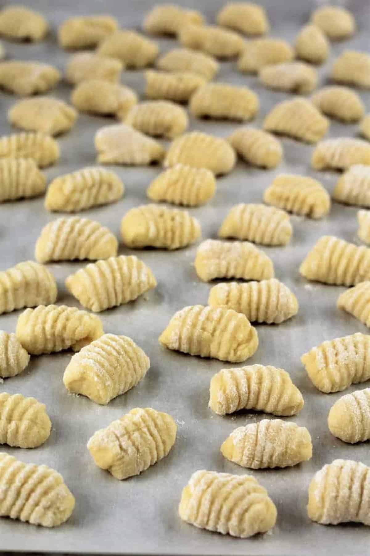 Ricotta gnocchi pieces on baking sheet.