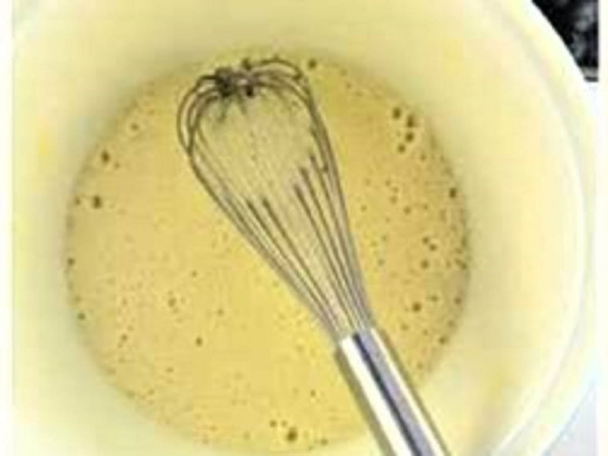 Eggs, sugar and oil whisked in bowl for olive oil cake.