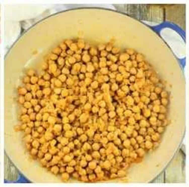 Chickpeas added to large skillet with onion and garlic for pasta recipe.