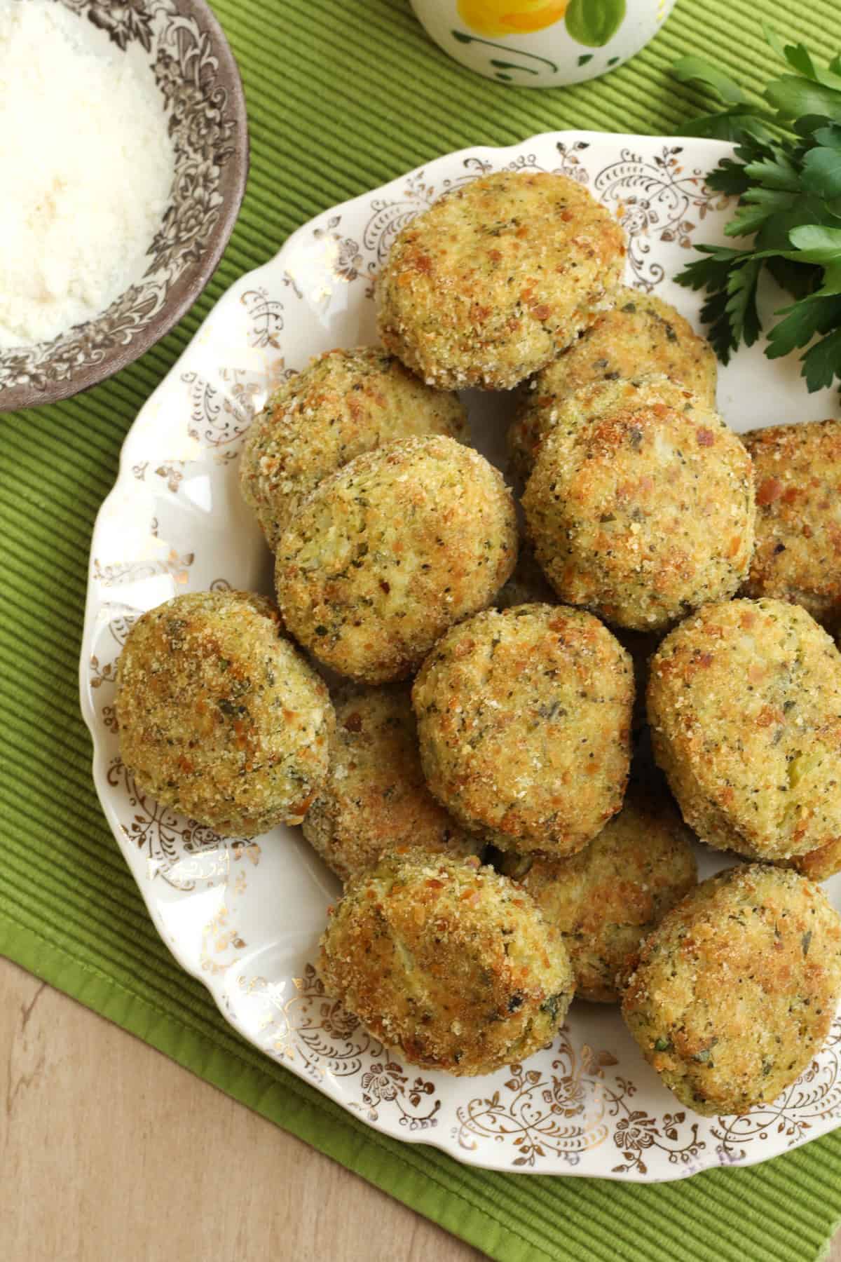 Breaded baked potato broccoli meatballs on serving plate.