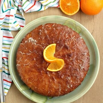 Sicilian whole orange cake, pan d'arancio, on plate topped with orange slice.