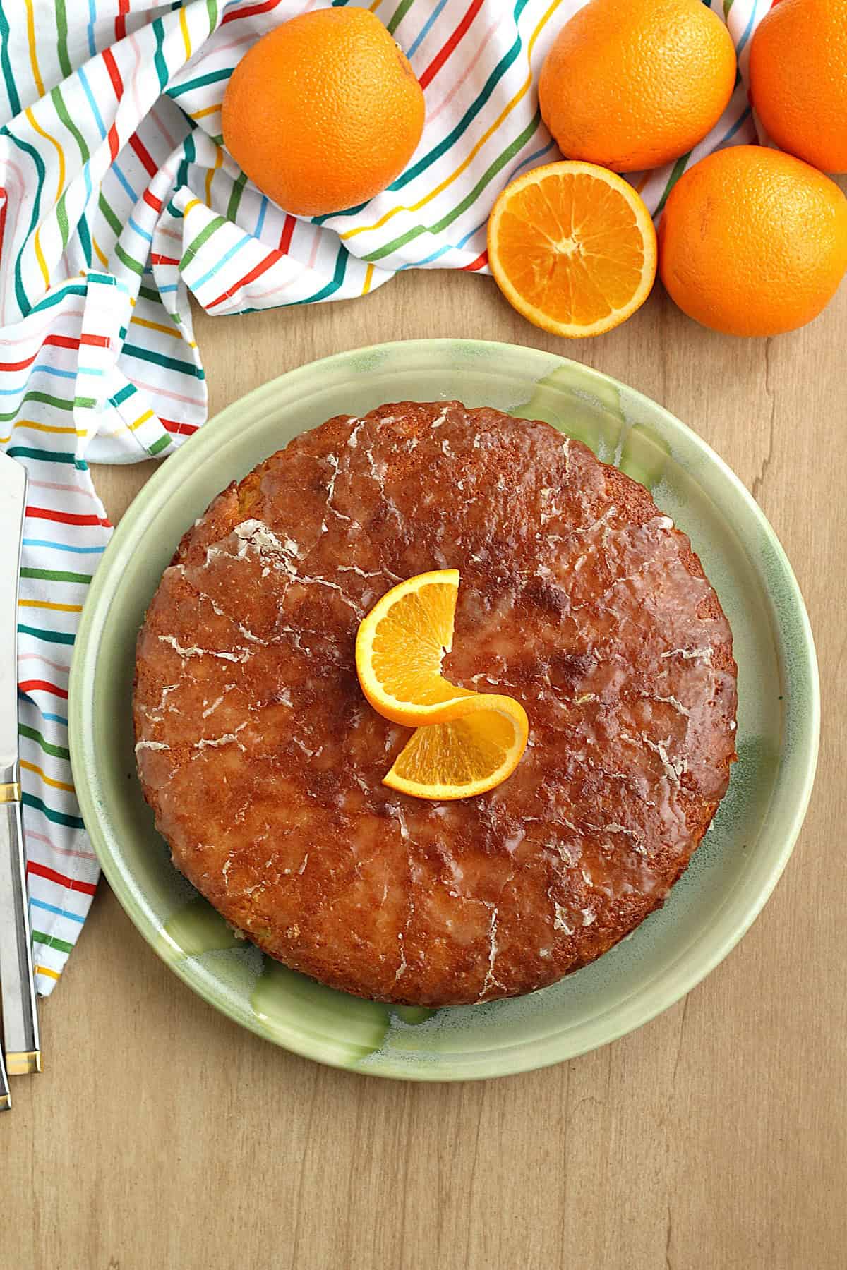 Sicilian whole orange cake, pan d'arancio, on plate topped with orange slice.