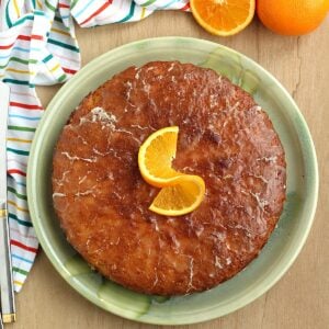Pan d'arancio, Sicilian whole orange cake, on plate topped with orange slice.